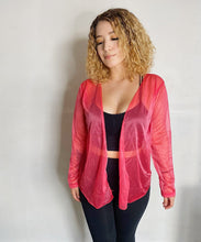 Load image into Gallery viewer, Girl with curly hair wearing a pink cardigan.